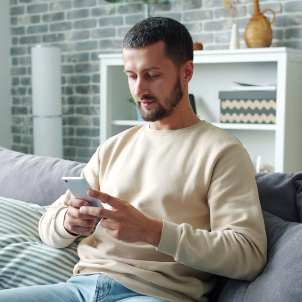 Man reviewing his investing plan on his phone at home