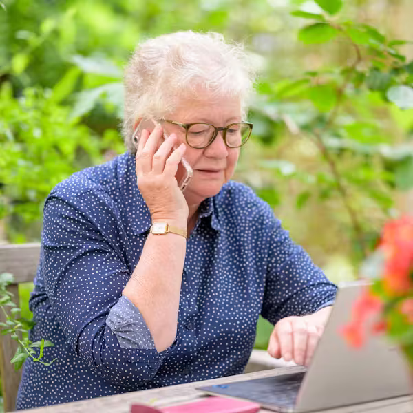 Older woman working on her laptop outdoors